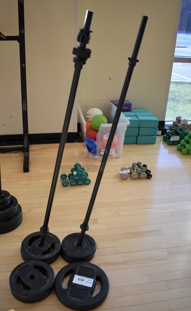 7 Various Les Mills Weight Plates w/ 2 Metal Body Bars; Six 5.5 Pounds and One 11 Pounds. 52" BUYER MUST REMOVE. (aerobic room)