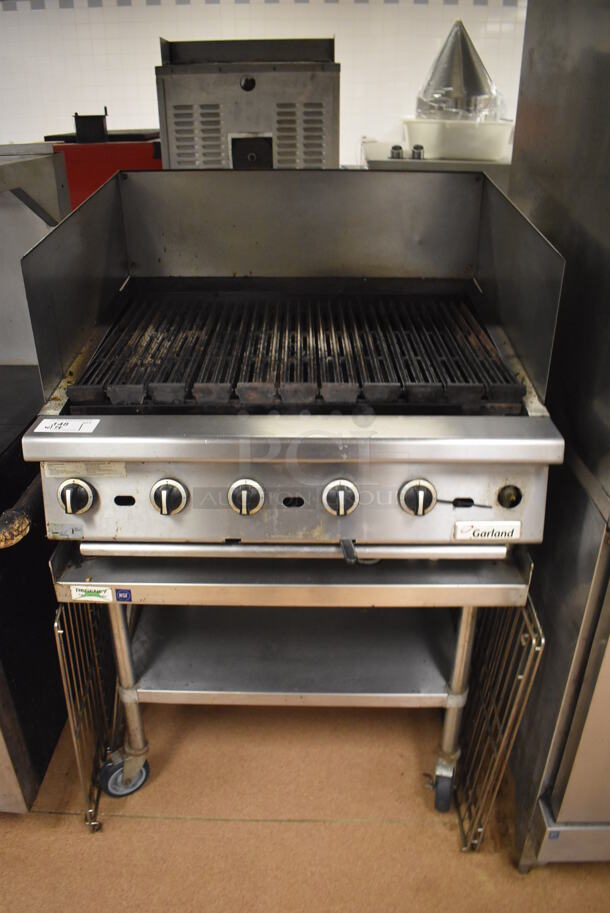 LATE MODEL! Garland Stainless Steel Commercial Countertop Gas Powered Charbroiler Grill w/ Side Splash Guards on Regency Stainless Steel Equipment Stand on Commercial Casters. BUYER MUST REMOVE. 35.5x32x26, 36x30x30. Tested and Working! (Restaurant Kitchen)