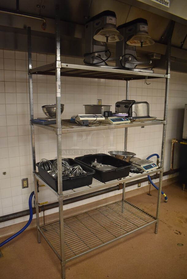 Metal 4 Tier Wire Shelving Unit w/ Contents Including Attachments and Scale. Does NOT Include The 2 Mixers on the Top Shelf. BUYER MUST DISMANTLE. PCI CANNOT DISMANTLE FOR SHIPPING. PLEASE CONSIDER FREIGHT CHARGES. 48x24x84. (Education Kitchen 2)