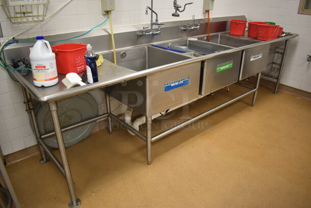 Stainless Steel Commercial 3 Bay Sink w/ Dual Drain Boards, 2 Faucets, 2 Handle Sets and Spray Nozzle Attachment. BUYER MUST REMOVE. 134x36x43. Bays 24x30x14. Drain Boards 28x32x2. (Education Kitchen)