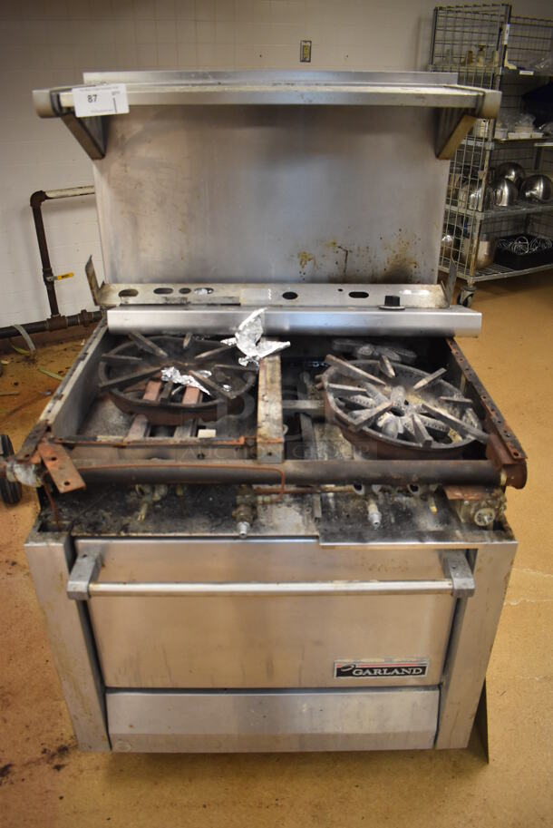 Garland M42-6R Stainless Steel Commercial Natural Gas Powered 2 Burner Range w/ Flat Top, Oven, Over Shelf and Back Splash. BUYER MUST REMOVE. 34x38x58. For Parts. (Education Kitchen)