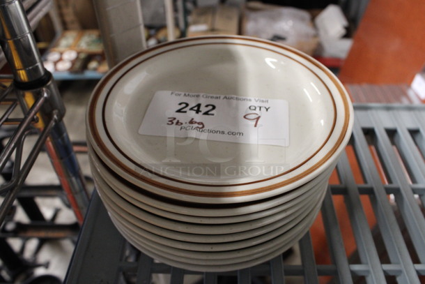 9 White Ceramic Plates; 3 w/ Brown Rim and 6 w/ Green Rim. 7.25x7.25x1. 9 Times Your Bid!