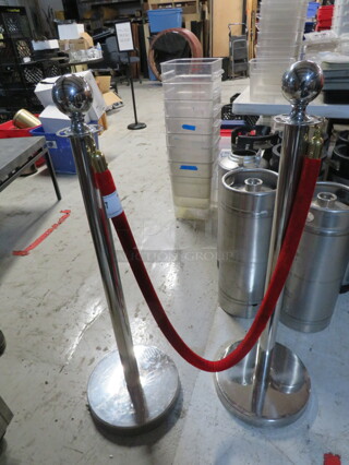 One Set Of 2 Crowd Control Poles With A Red Velvet Rope.