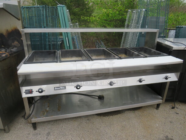 One Vollrath 5 Well Steam Table With Over/Under Shelf And Cutting Board. 208-240 Volt. Model# 38119. WORKING WHEN REMOVED 75X33X46.5