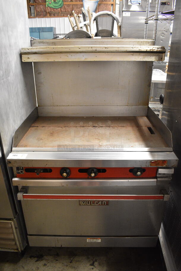 Vulcan 36XTL-559 Stainless Steel Commercial Propane Gas Powered Flat Top Griddle w/ Oven, Over Shelf and Back Splash on Commercial Casters.