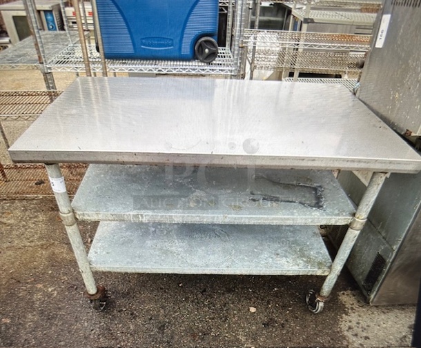 One Stainless Steel Table With 2 Under Shelves On Casters. 48X30X34