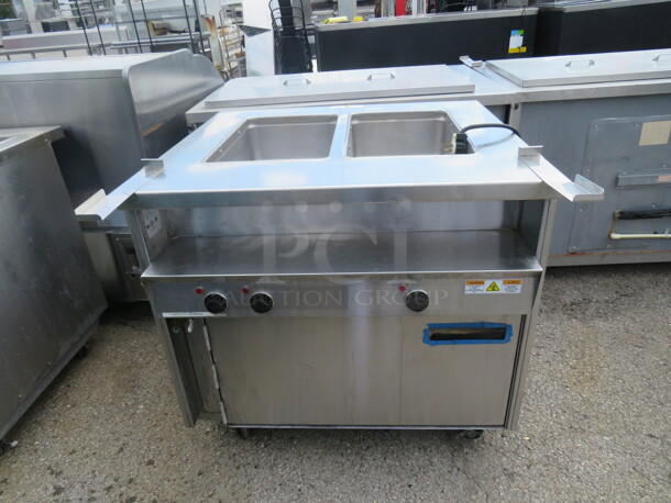 One SS Randell 2 Well Steam Table With 1 Door Warmer Under On Casters. Model# 31330. 208/240 Volt. 1 Phase. 33X33X35