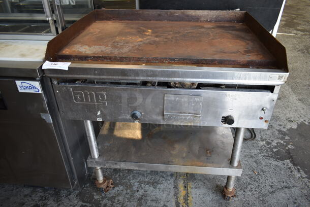 Lang G-3E Stainless Steel Commercial Natural Gas Powered Flat Top Griddle w/ Metal Under Shelf on Commercial Casters. 27,000 BTU. 