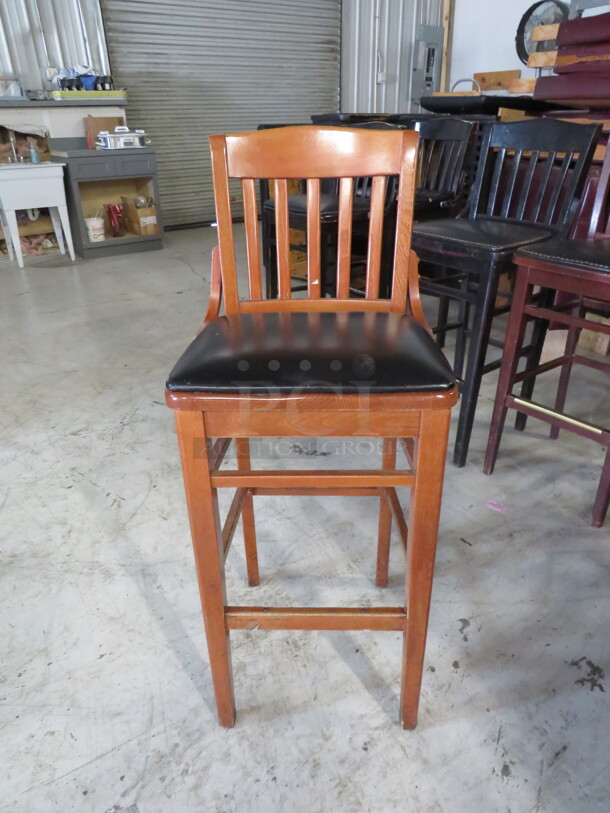 One Wooden Bar Height Chair With A Black Cushioned Seat. 