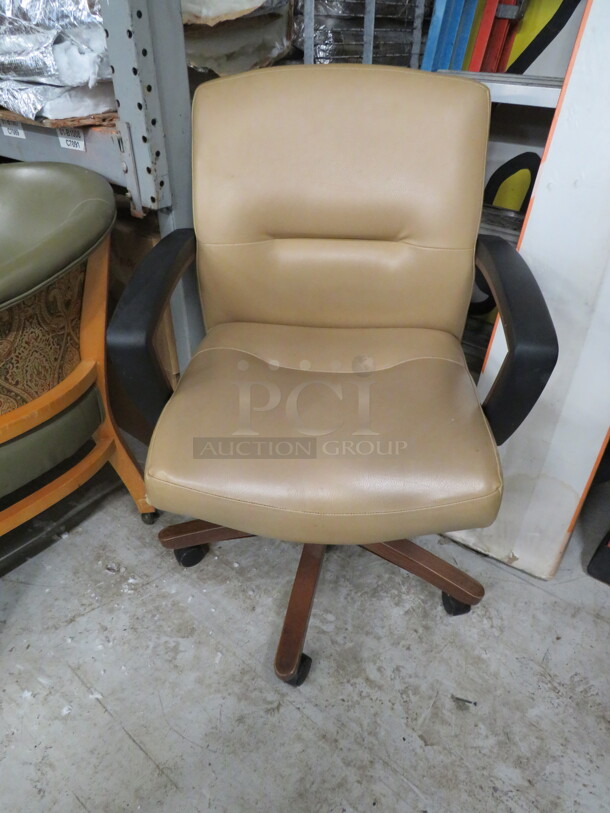 One Wooden Office  Chair With A Beige Cushioned Seat And Back On Casters. 