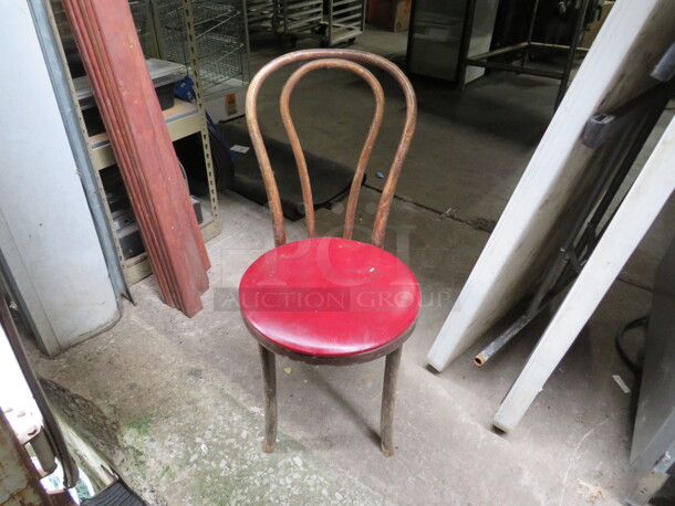 One Wooden Chair With Red Cushioned Seat.