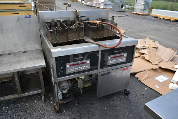 Henny Penny Stainless Steel Commercial Floor Style Natural Gas Powered 2 Bay Deep Fat Fryer w/ 4 Metal Fry Baskets on Commercial Casters.
