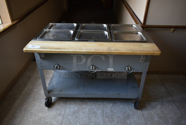 Stainless Steel Commercial 3 Well Steam Table w/ Butcher Block Cutting Board and Under Shelf on Commercial Casters. Tested and Does Not Power On. (front hallway)