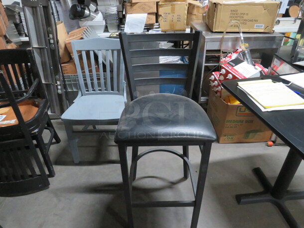 One Black Metal Bar Height Chair With Cushioned Seat.