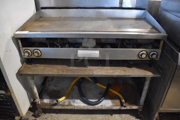Stainless Steel Commercial Countertop Natural Gas Powered Flat Top Griddle w/ Thermostatic Controls and 2 Gas Hoses on Metal Commercial Equipment Stand. 48x25x18, 49x28x25