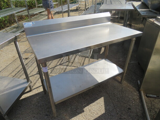 One Stainless Steel Table With Stainless Under Shelf, And Back Splash. 48X24X40