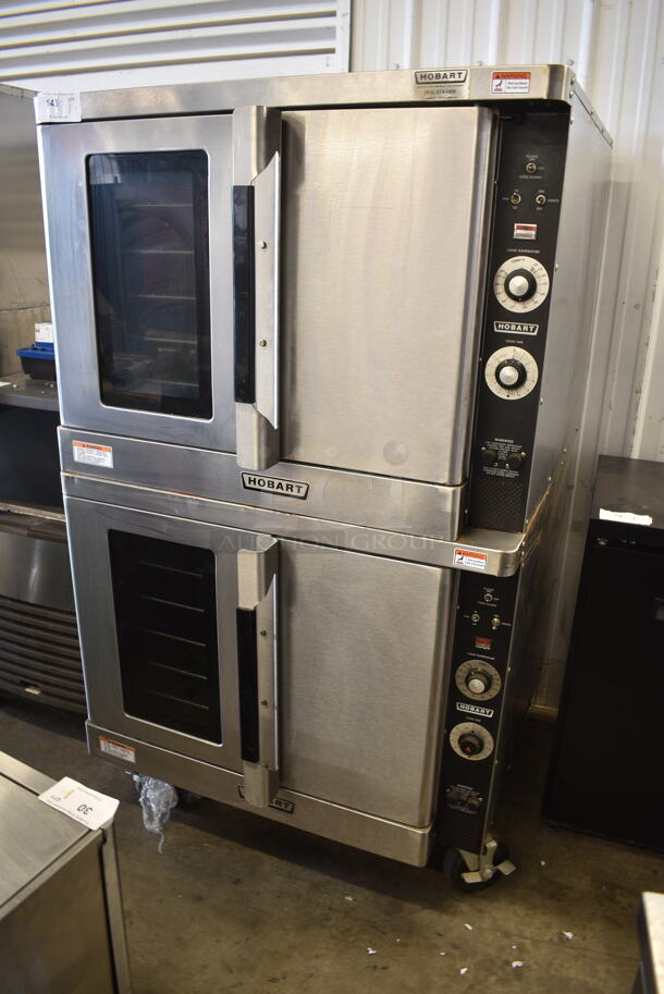 2 Hobart Stainless Steel Commercial Electric Powered Full Size Convection Oven w/ View Through Door, Solid Door, Metal Oven Racks and Thermostatic Controls on Commercial Casters. 208-240 Volts, 1/3 Phase. 2 Times Your Bid!